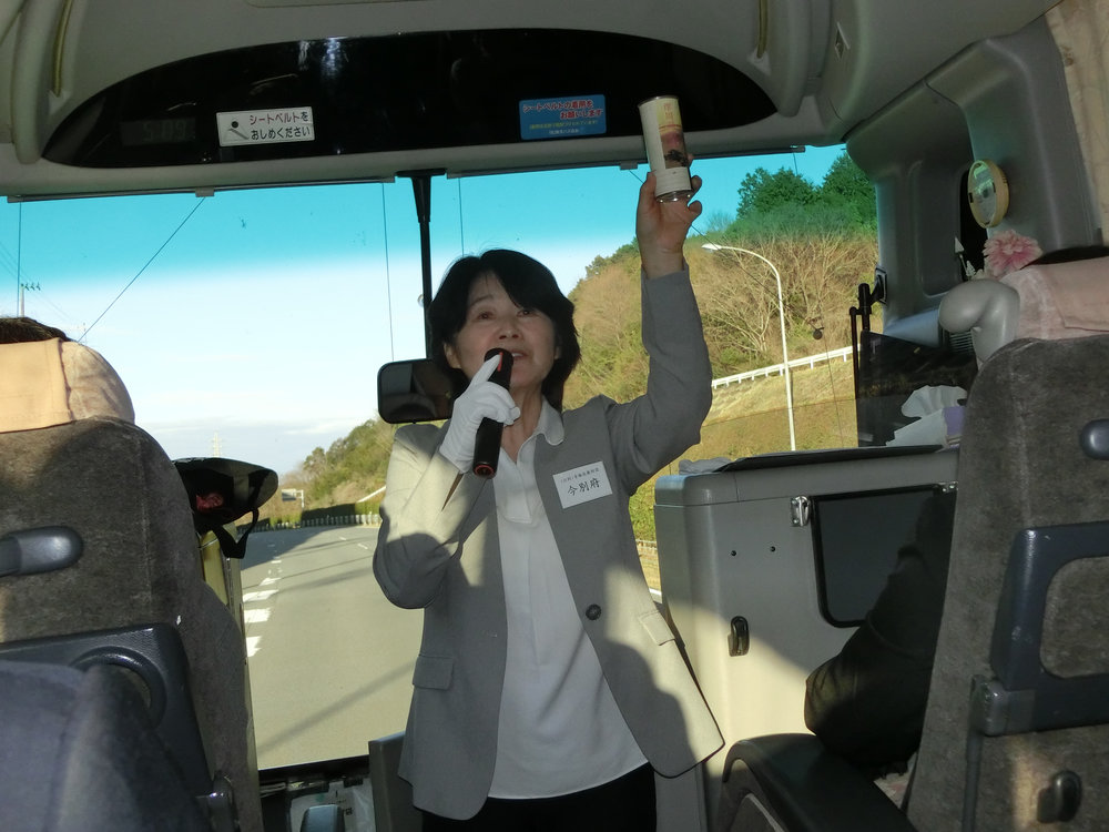 バス車内で説明するガイドの今別府さん