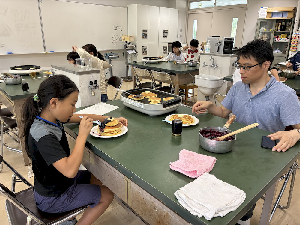 ブルーベリージャムを添えたパンケーキを食べる参加者